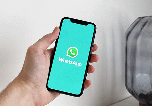 mão segurando um celular com o aplicativo do whatsapp